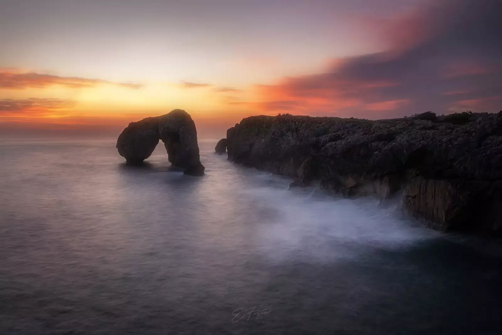 Arco de roca del Castro de las Gaviotas al atardecer, Asturias