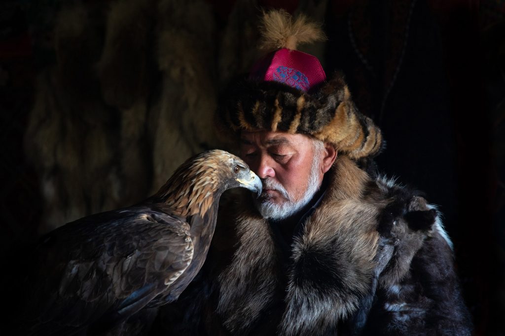 fotografía de retrato en viajes de un cazador con águila en Mongolia