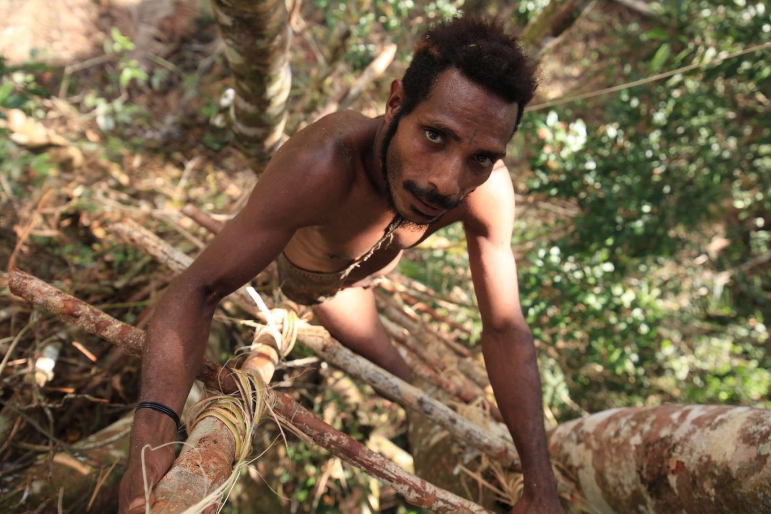 papua indigenous climbing stairs