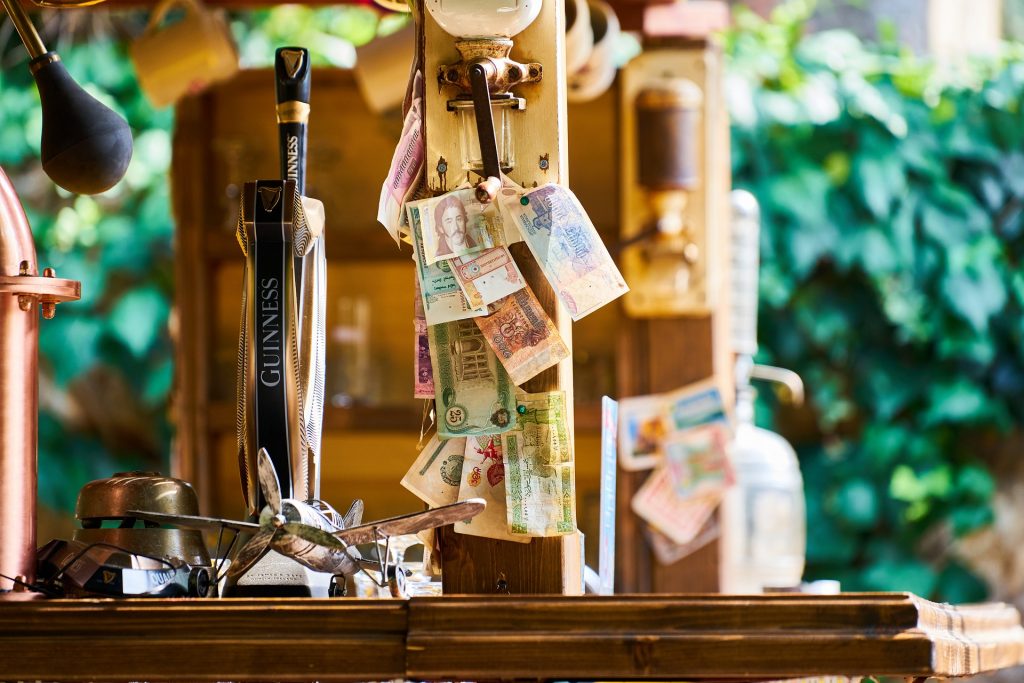 Diferentes monedas internacionales en una cervecería sin tarjeta de débito